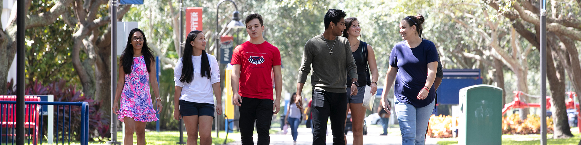 Students walking across the Jupiter campus under trees