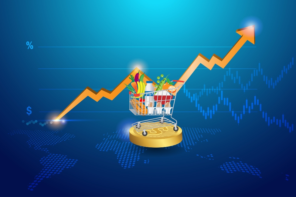 A graphic of a shopping cart filled with groceries on top of a circular gold coin with an arrow pointing up. The graphic is over a blue background.